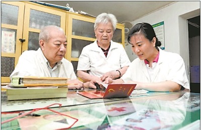 上图:彭天冰与父母一起讨论医疗义诊活动方案。石祯专 摄