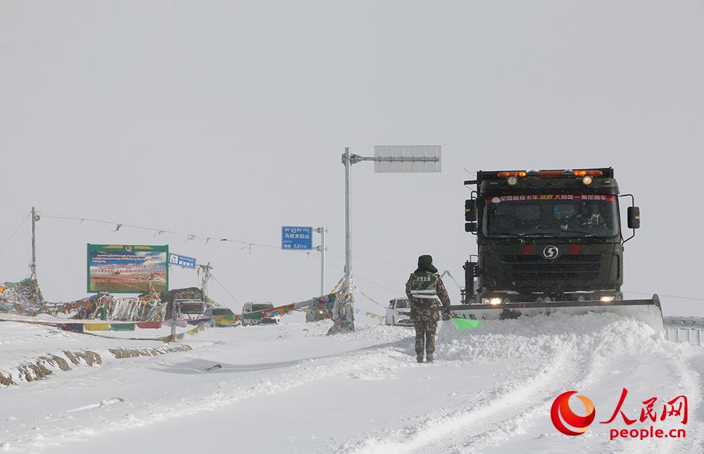 武警官兵在海拔5000多米的马攸木拉达坂清理路面积雪。