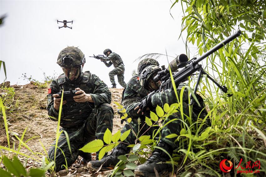 无人机操作手运用无人机侦察为狙击手寻找打击目标。