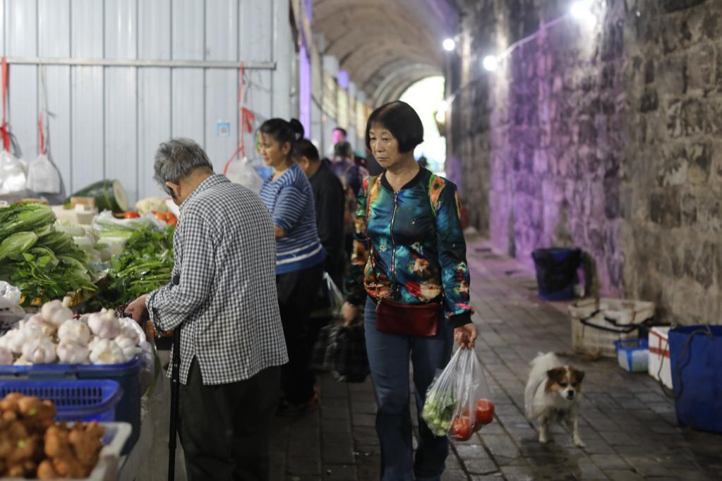 9月25日，居民在“洞子菜市”的摊位前挑选蔬菜。新华社记者周思宇 摄